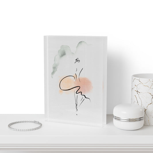 Art print of a stylized face with abstract elements on a white surface, next to a bracelet and a small container.