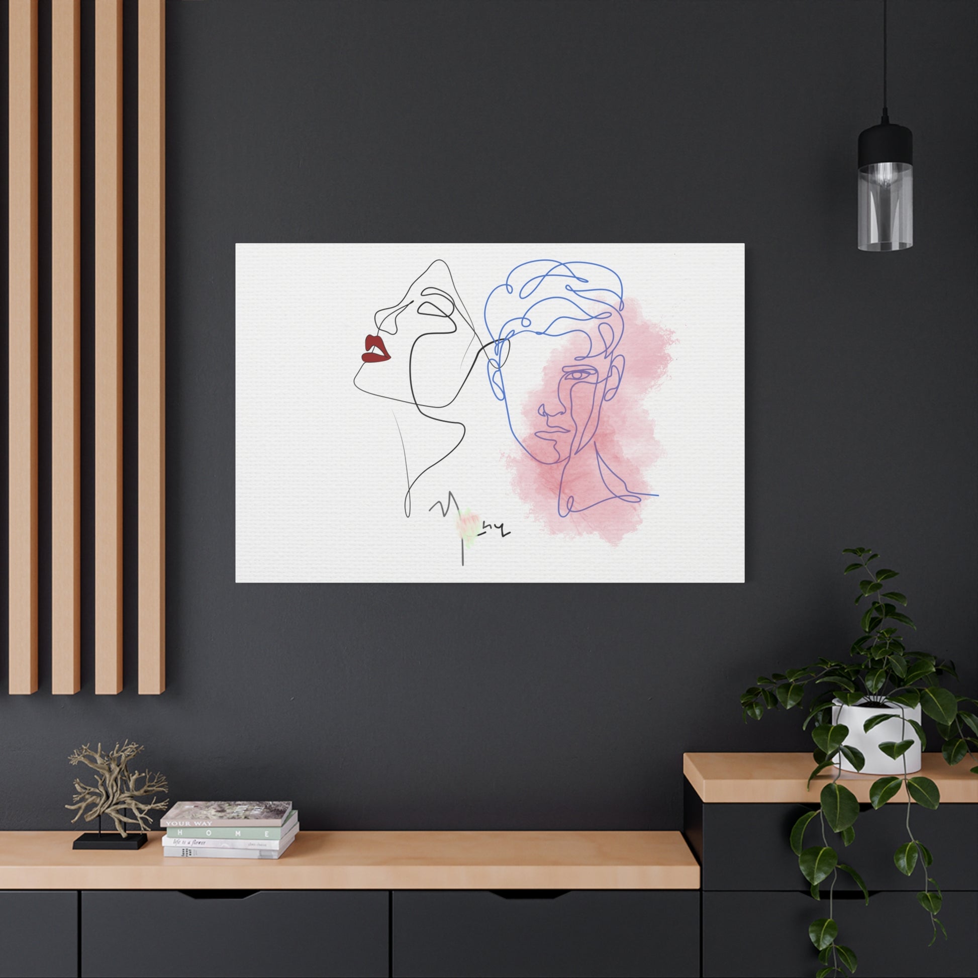 Modern interior with abstract line art of two faces on a white background, framed on a dark wall.