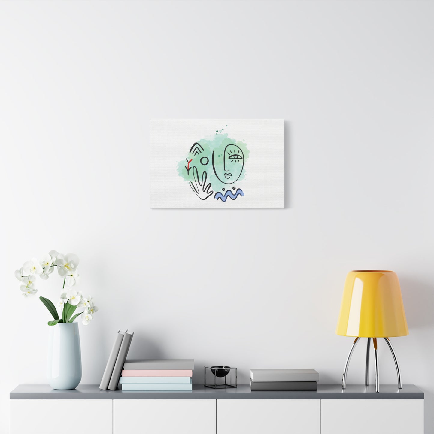 Framed artwork on a wall above a table with decor items